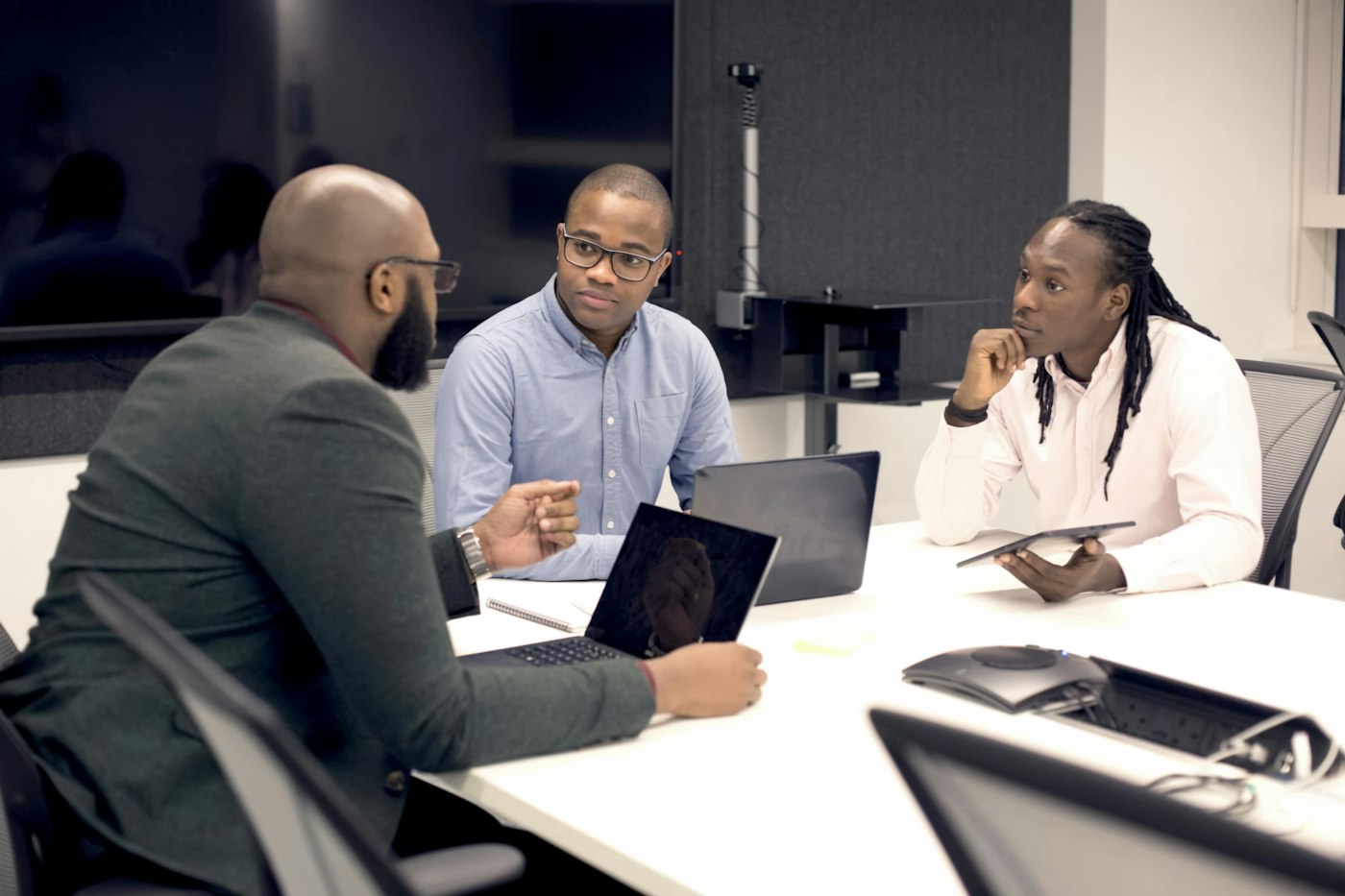 Consultants in a meeting around a table with laptops