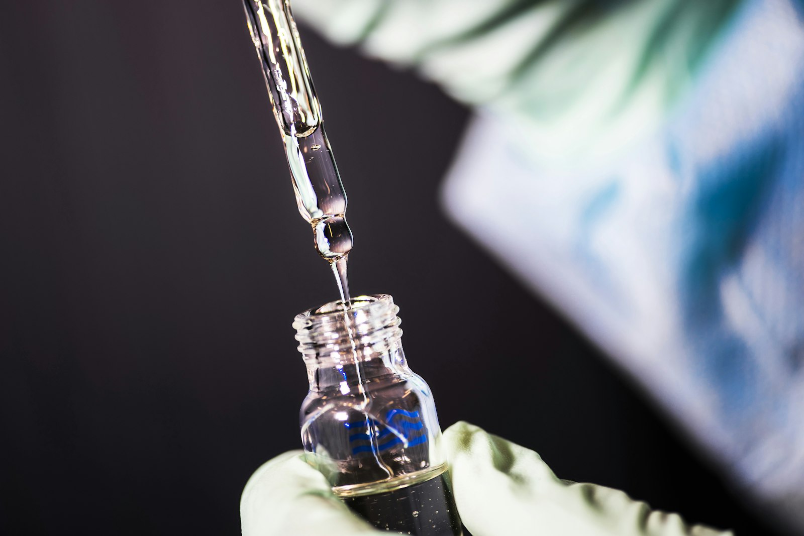 A pipette dispensing liquid into a glass vial
